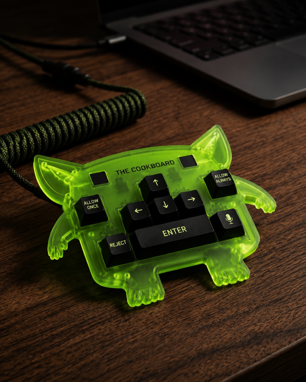 The Cook Board Goblin Edition on a wooden desk beside a laptop